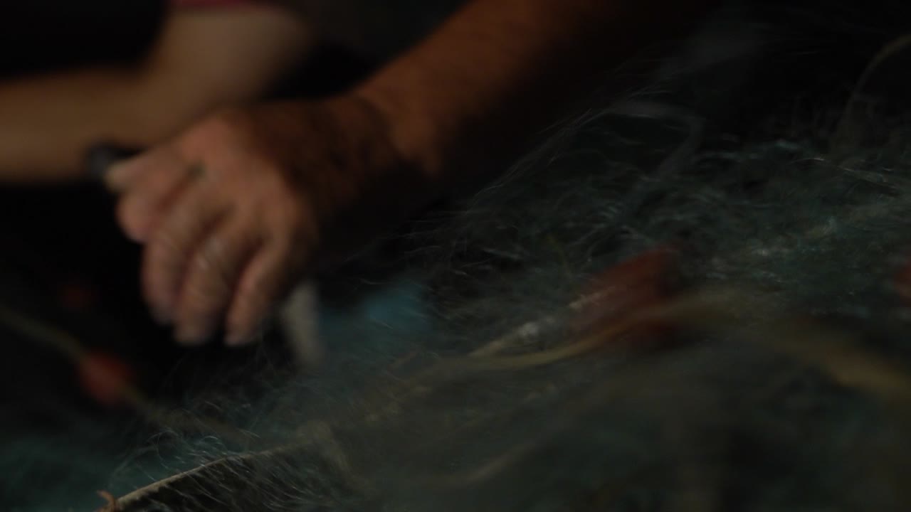 Un pescatore cala la sua rete da pesca mentre pesca a strascico di notte.