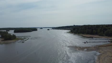 on either side of the wide water body, the banks are adorned with lush greenery, creating a picturesque scene