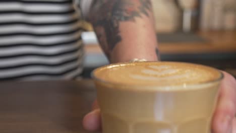 serving latte in a glass. coffee shop concept. close up