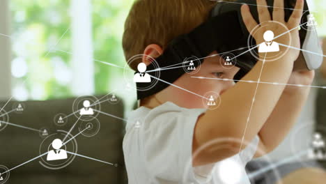 animation of network of connections with icons over caucasian boy using vr headset