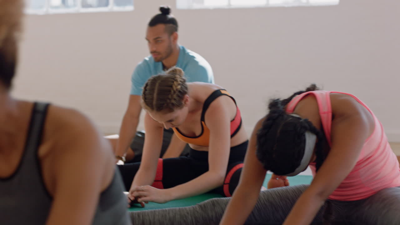 grupo de clase de yoga de jóvenes multirraciales practicando poses estirando el cuerpo disfrutando de un estilo de vida saludable haciendo ejercicio en el gimnasio