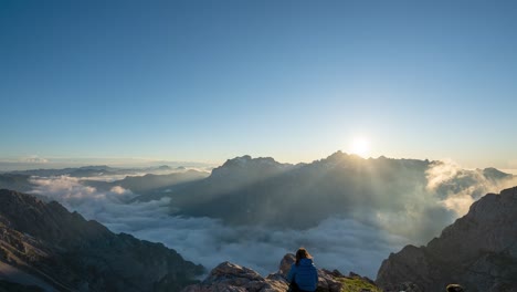 excursionista observa la majestuosa puesta de sol con nubes bajas en el refugio de collado jermoso en picos de europa, leon, españa