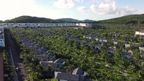 drone flyover touristic villas from hotel resort surrounded by lush vegetation, phu quoc island, vietnam