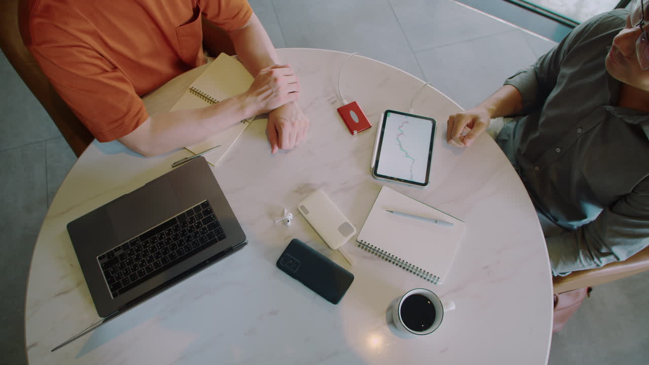 Financial Analysts Discussing Details of Project at Round Table Top View