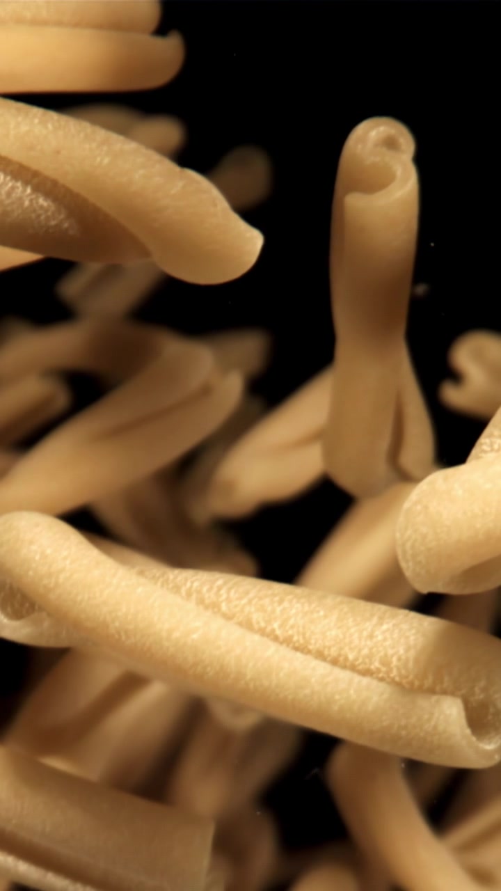 Pasta secca che cade al rallentatore su sfondo nero