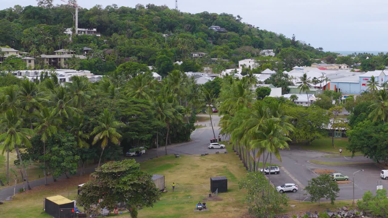 Aerial footage captures lush greenery and urban structures in Port Douglas, Queensland, under soft daylight with a serene atmosphere