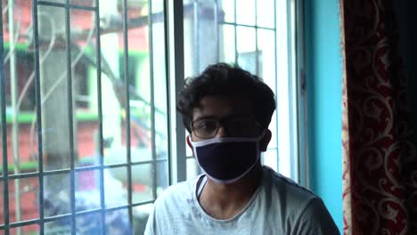 sad young asian male looks at camera and nods his head side ways saying no, lockdown in india due to corona virus