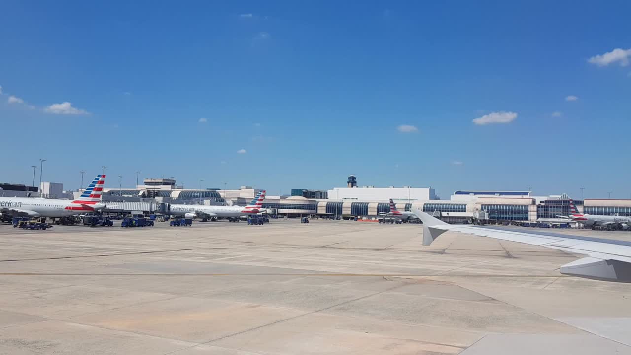 Busy Dallas Texas airport, riding in airplane to gate.