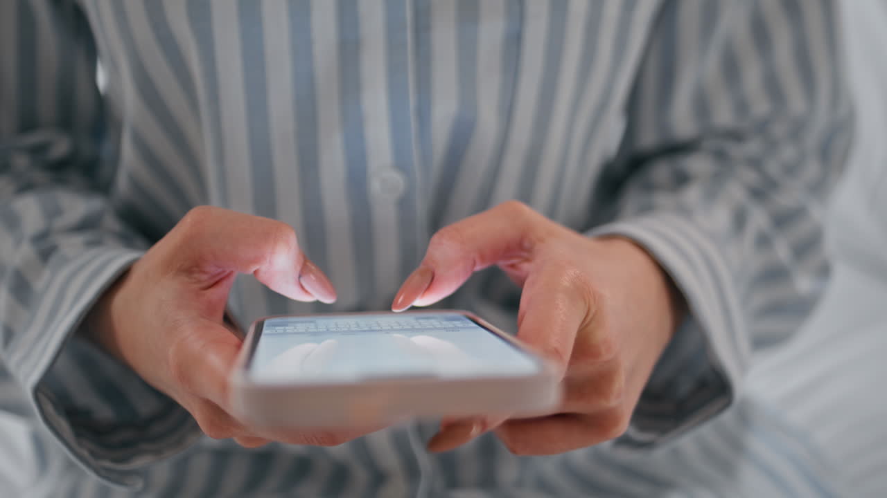Girl hands typing smartphone in bedroom closeup. Lady creating posts on phone