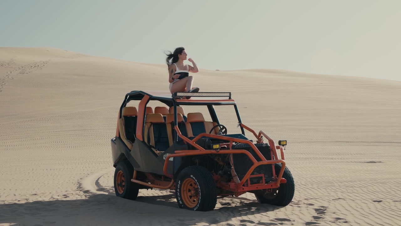 Eine Frau sitzt auf einem Sandbuggy in Huacachina, Ica, Peru – Halbnahe Einstellung.