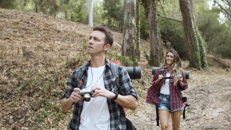 couple of hikers with camera taking photos of landscape