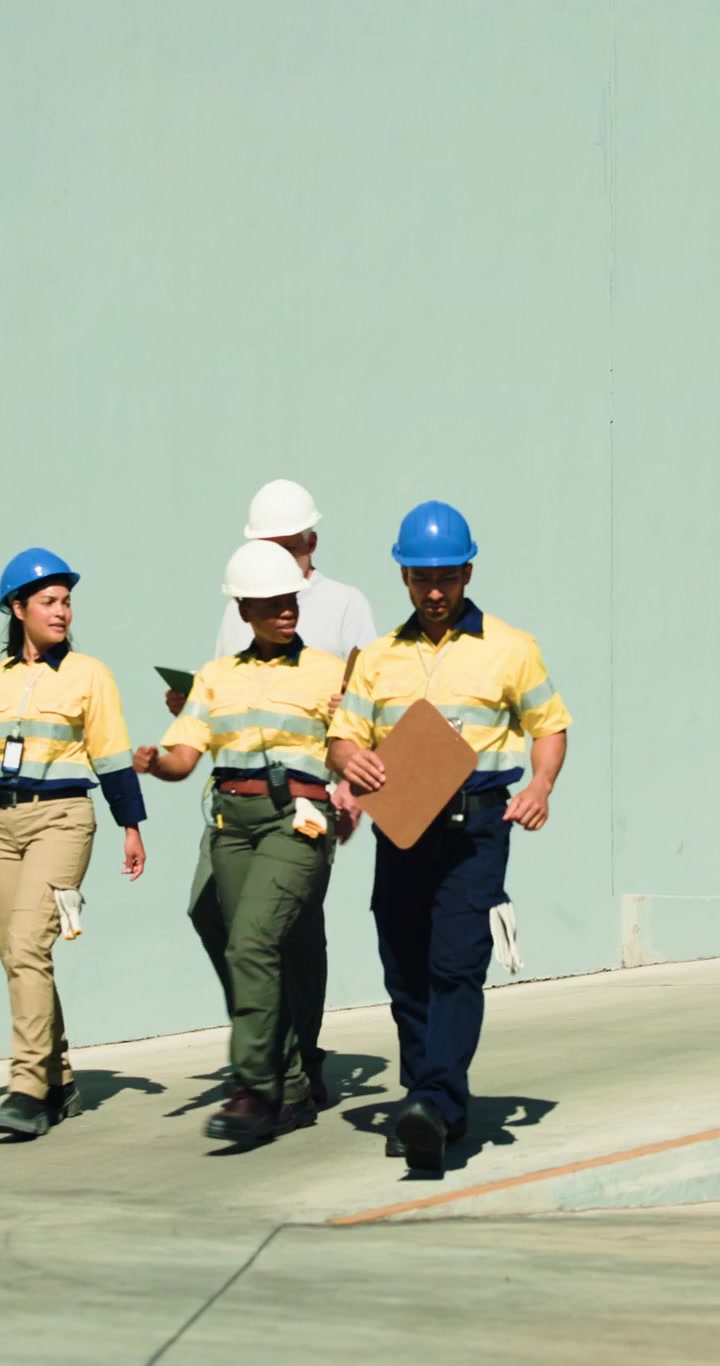 Diverse Team of Construction Workers Walking and Discussing Project