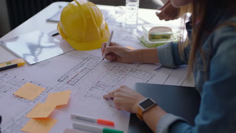 close up architects using building plans business women working together on construction project team of engineers brainstorming design solution planning successful development strategy