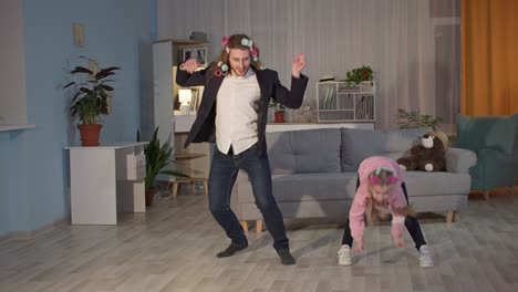 joyful friendly family father and daughter are jumping and dancing merrily in living room during self-isolation and quarantine, stay at home