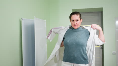 therapist confidently wears uniform while scanning room with attentive gaze inside clean medical facility, preparing for workday responsibilities in clinical setting under bright lighting