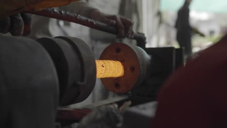 ironworker forging metal on a hot lathe in a workshop in pakistan