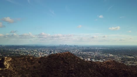 wide aerial shot of downtown los angeles with hikers on mountain in the foreground