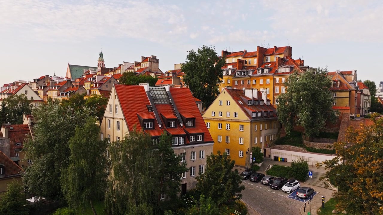 Veduta aerea introduttiva di Varsavia che mostra l'architettura del quartiere storico sotto una calda luce solare.