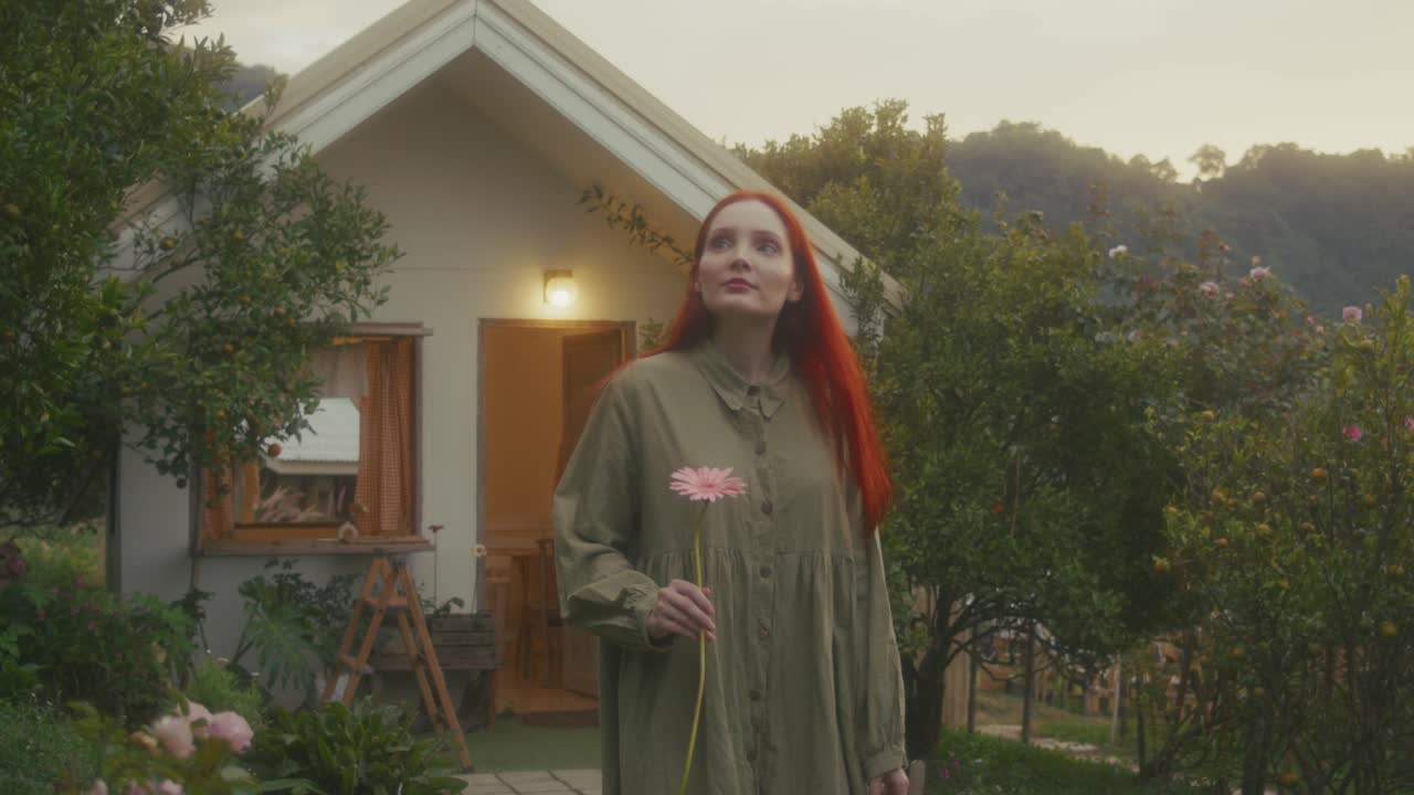 Woman Walking in a Garden by a Cottage