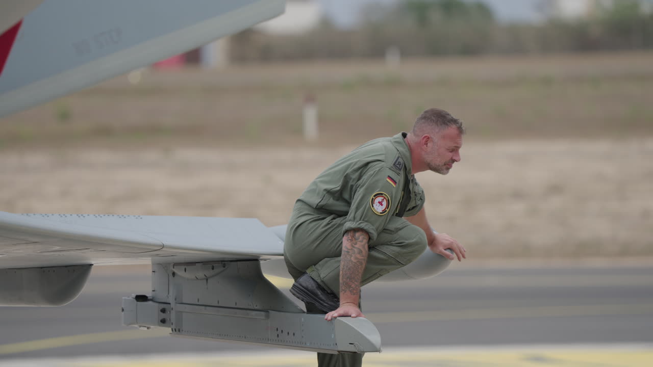 Piloti militari che si rilassano sull'ala di un jet da combattimento sul piazzale