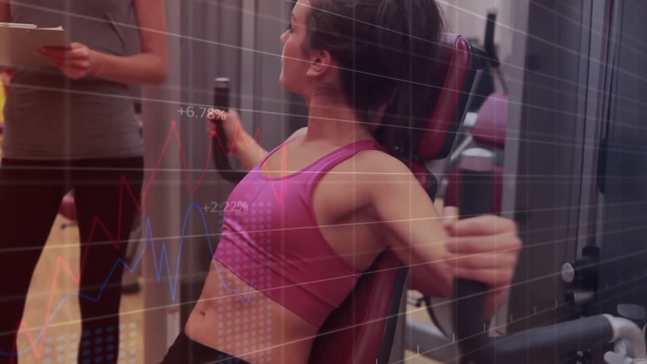 Fitness trainer monitoring client pressing resistance machine in gym with floating metrics charts