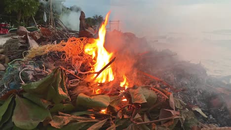 burning leaves and plastic at beach of gili air island,indonesia