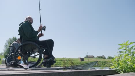 man with disabilities fishing at a lake. wheelchair. summertime. disabled person fishing