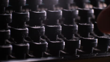 fingers of person pressing old vintage typewriter buttons, close up view