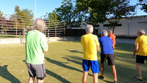 senior men cheering up sportsman who scoring penalty goal