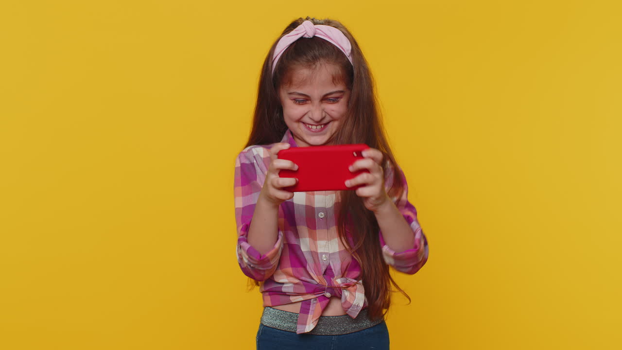 niña emocionada preocupada jugando a carreras o simulador de disparos aplicación de gadget videojuegos en el teléfono inteligente