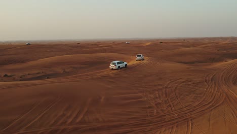 white suvs off-roading in the desert