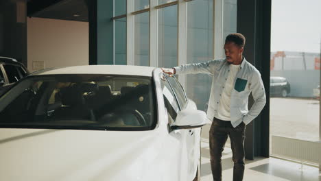 man checking a white car in a showroom