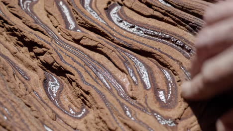 close-up view of layered rock formation with a hand