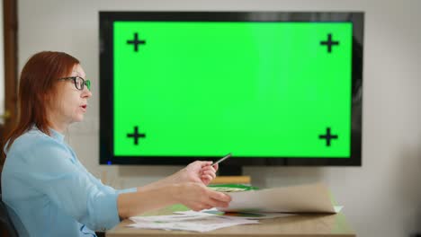 gerente caucásica inteligente a la izquierda hablando analizando proyecto mirando borrosa pantalla chromakey en el fondo. mujer hablando persuadiendo en la rentabilidad del proyecto en línea. concepto de conferencia.