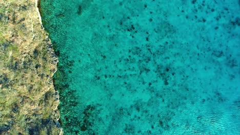 Perspectiva-A-Vista-De-Pájaro-Del-Acantilado-Y-Las-Ondulaciones-Del-Agua-Del-Océano-En-El-Claro-Mar-Caribe