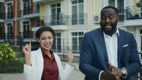 Portrait-of-happy-business-people-celebrating-victory-outdoors.-Couple-dancing