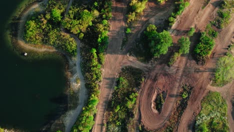 Von-Oben-Nach-Unten-Luftaufnahme-Von-Motocross-Fahrern,-Die-Auf-Dirt-Bike-Strecken-Abseits-Der-Straße-Fahren