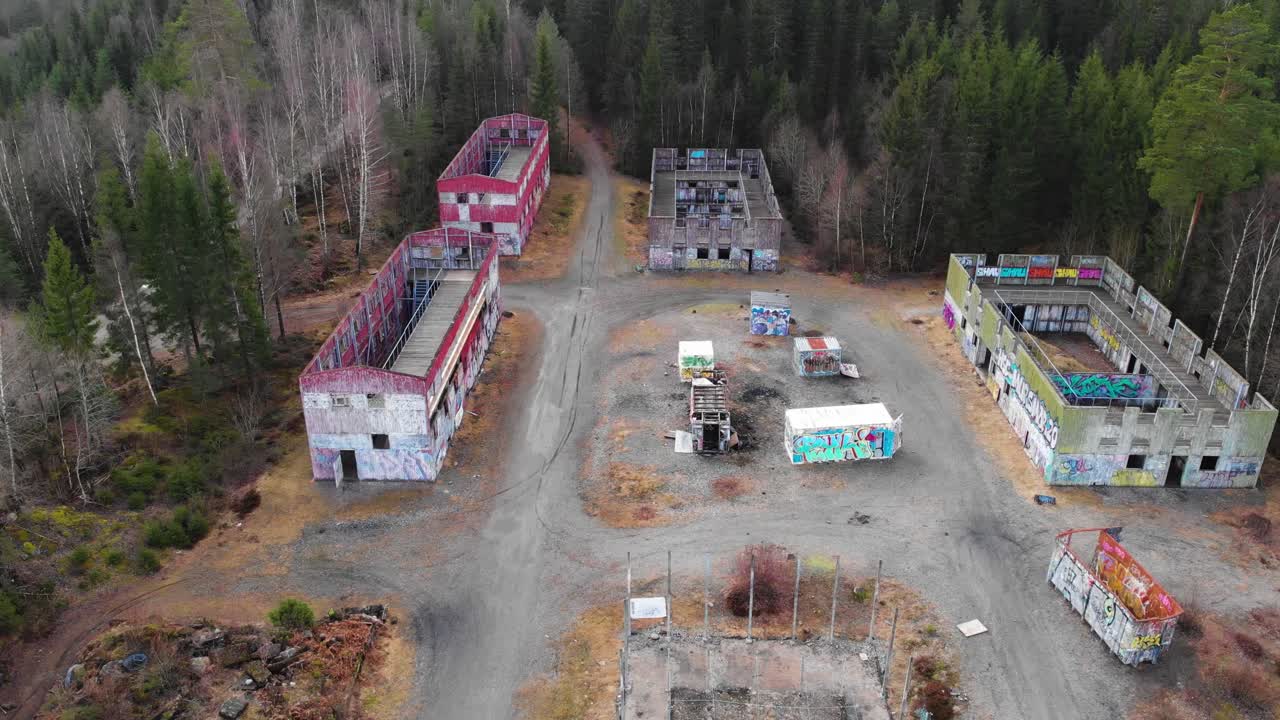 숲으로 둘러싸인 파괴된 건물이 있는 빈 버려진 지역의 공중 하향식