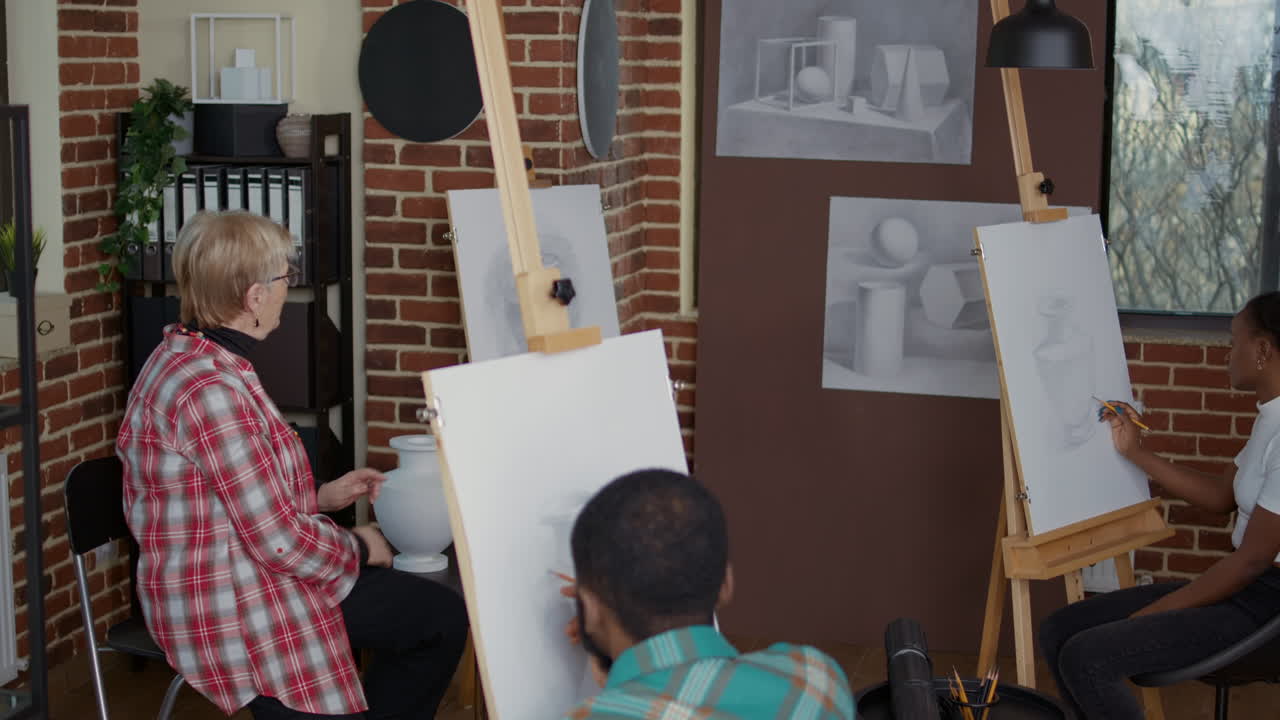 Elder teacher explaining drawing technique to students in art class