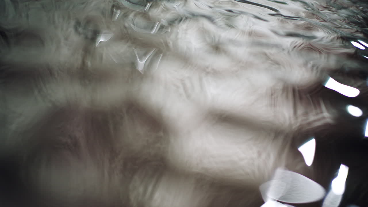 Macro shot of water ripples with light reflections and fluid motion