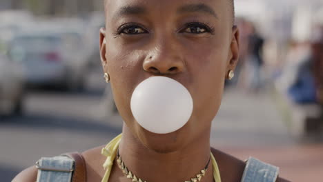 Portrait-happy-african-american-woman-smiling-blowing-bubblegum