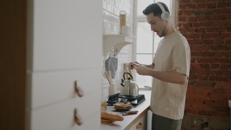 man making toast in kitchen