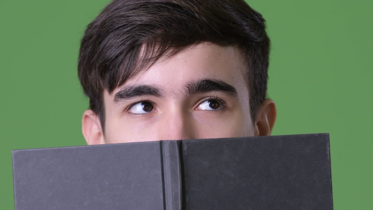 초록색 배경에 젊은 잘생긴 이란 십대 소년