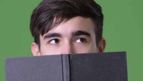 joven y guapo adolescente iraní contra un fondo verde