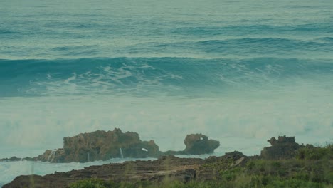 rolling ocean waves of the pacific crash onto the rocky shore of kaena point ,oahu ,hawaii