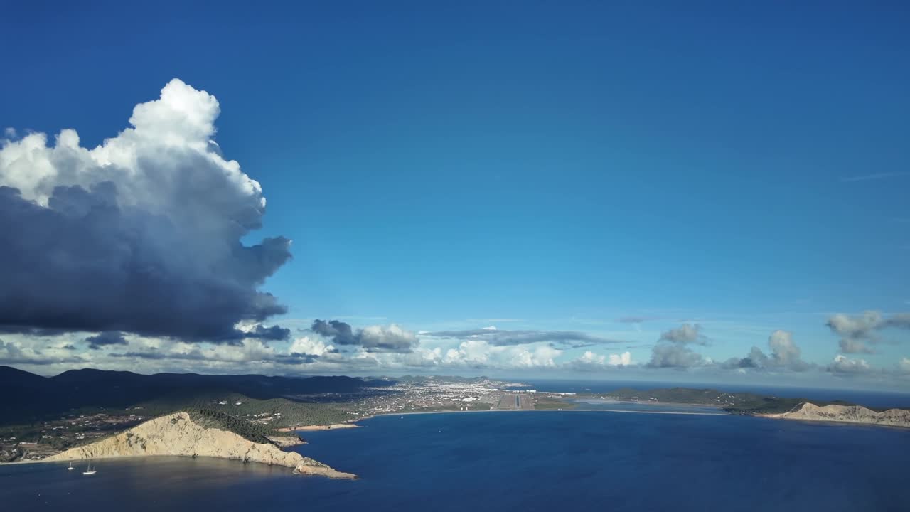 Pilot’s FPV POV in a real time approach to land at Ibiza’s airport Runway 06 overflying the sea with a stormy cloud in a deep blue sky. 4K 60FPS