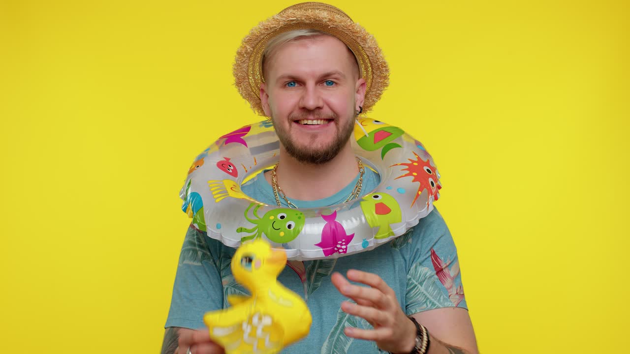 hombre sonriendo en un traje de verano con un flotador de piscina