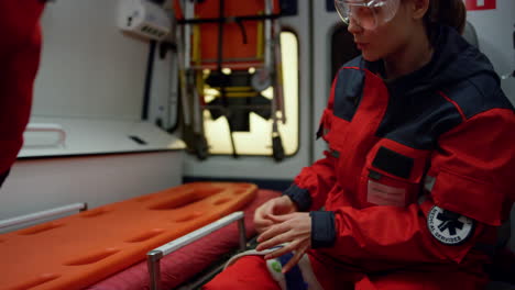 paramedic working in ambulance car. medic practicing first aid with immobilizer