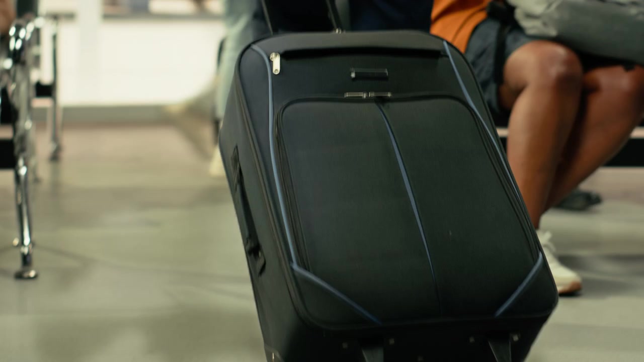 Nærbillede af travlhed på en busstation med en person, der bærer bagage.