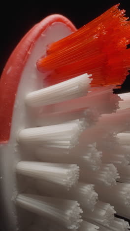 hard bristles texture of small toothbrush for children on black background. bright colourful brush for thorough cleaning teeth and cavity macro